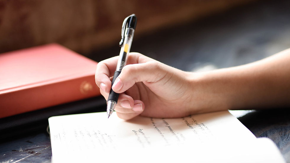 Hand holding a pen signing a document