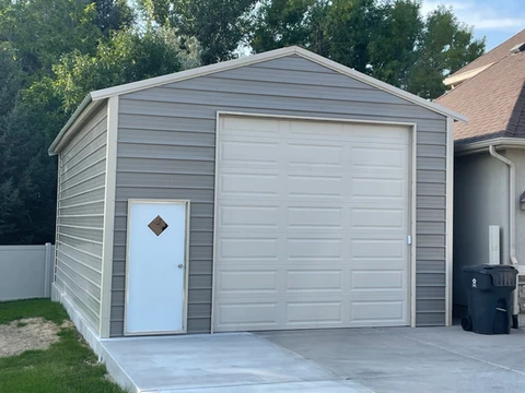 Gray metal building with a roll-up door and walk-in door
