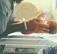 Clinician holding neonatal baby