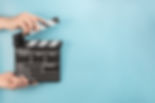 movie-clapperboard-hands-blue-space.jpg