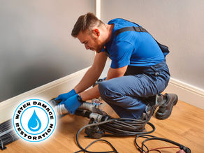 technician working on residential home water extraction with wet vacs, drying with air movers for property restoration