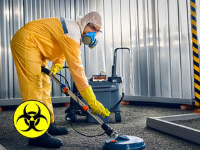 trauma biohazard professional in PPE using commercial equipment in a contained and orderly cleanup area