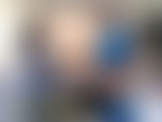 An appliance repair technician shaking hands with a homeowner in a modern kitchen