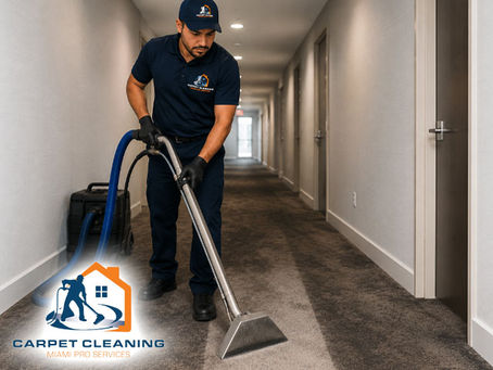 Technician deep-cleaning a dark, worn traffic lane in a hallway using a high-powered carpet cleaning wand