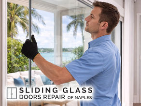 replacement technician lifting new glass panel into sliding door frame with coastal scenery in background