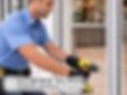 repair technician working on commercial sliding glass door entrance of office or retail storefront