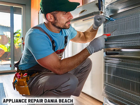 Technician inspecting refrigerator coils for repair in a coastal Florida kitchen, tools nearby and digital thermometer in hand