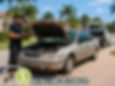 Old vehicle with hood open being evaluated by professional buyer, residential Florida setting, clean and organized environment