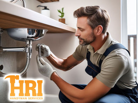 home repairs Technician inspecting a small plumbing leak under a bathroom sink in a modern residence