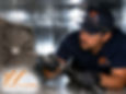 Technician using a rotary brush system inside a large metal duct for deep cleaning, detailed debris removal, bright lighting