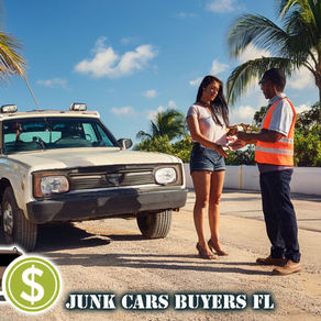 A person handing over car keys of junk car to a tow truck driver next to an old vehicle, with bright Florida sunlight and palm trees
