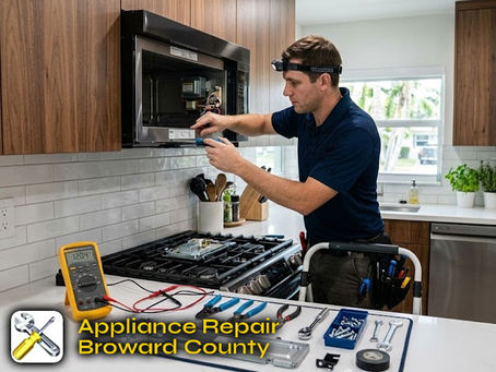 A professional repair technician repairing an over-the-range microwave in a modern kitchen, with tools and a voltage meter visible