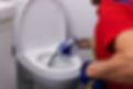 plumber_unclogging_residential_bathroom_toilet_with_hydro_jetting_method