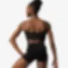Female dancer wearing black bralette-style dance top, showing wide back band and full shoulder coverage from behind.
