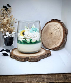 Handmade soy wax candle in glass with white, blue, and green whipped floral design, sunflower detail, and layered wax – MysticGlow artisanal candle.