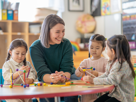 4 humains autour d'une table jouant avec des jeux pour enfant