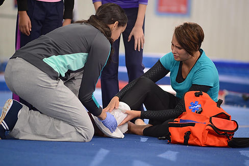 woman performing first aid for an ankle injury.jpg