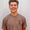 Thumbnail: Smiling young man in brown shirt, happy expression, standing in front
