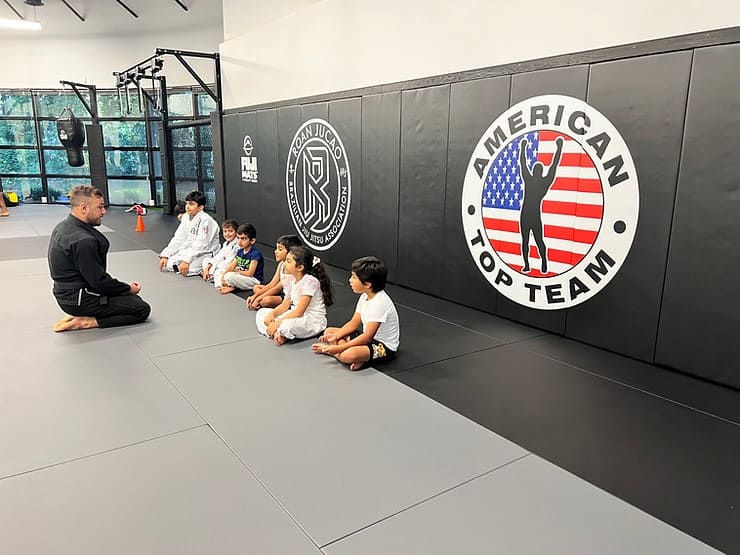 Instructor explaining Brazilian Jiu-Jitsu to children