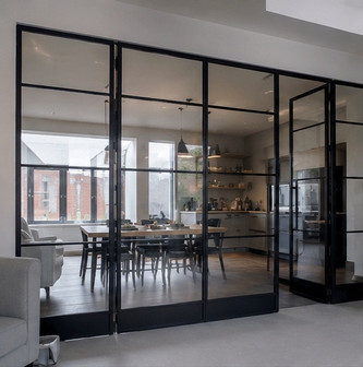 Bespoke black steel and glass partition installed by Swift Glazing in a modern London dining room.