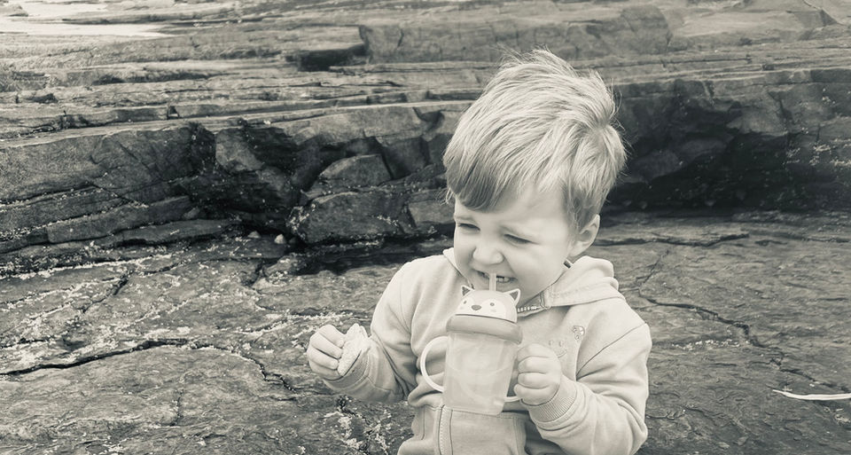 Boy eating biscuit on rocks