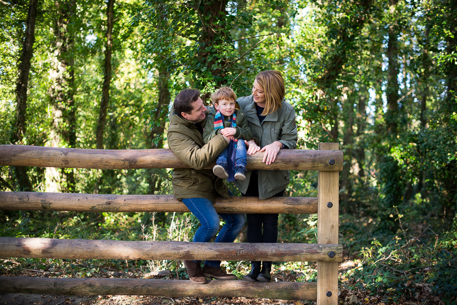 A family of a mother, father and son on. fence at the garden at Malahide Castle in Dublin