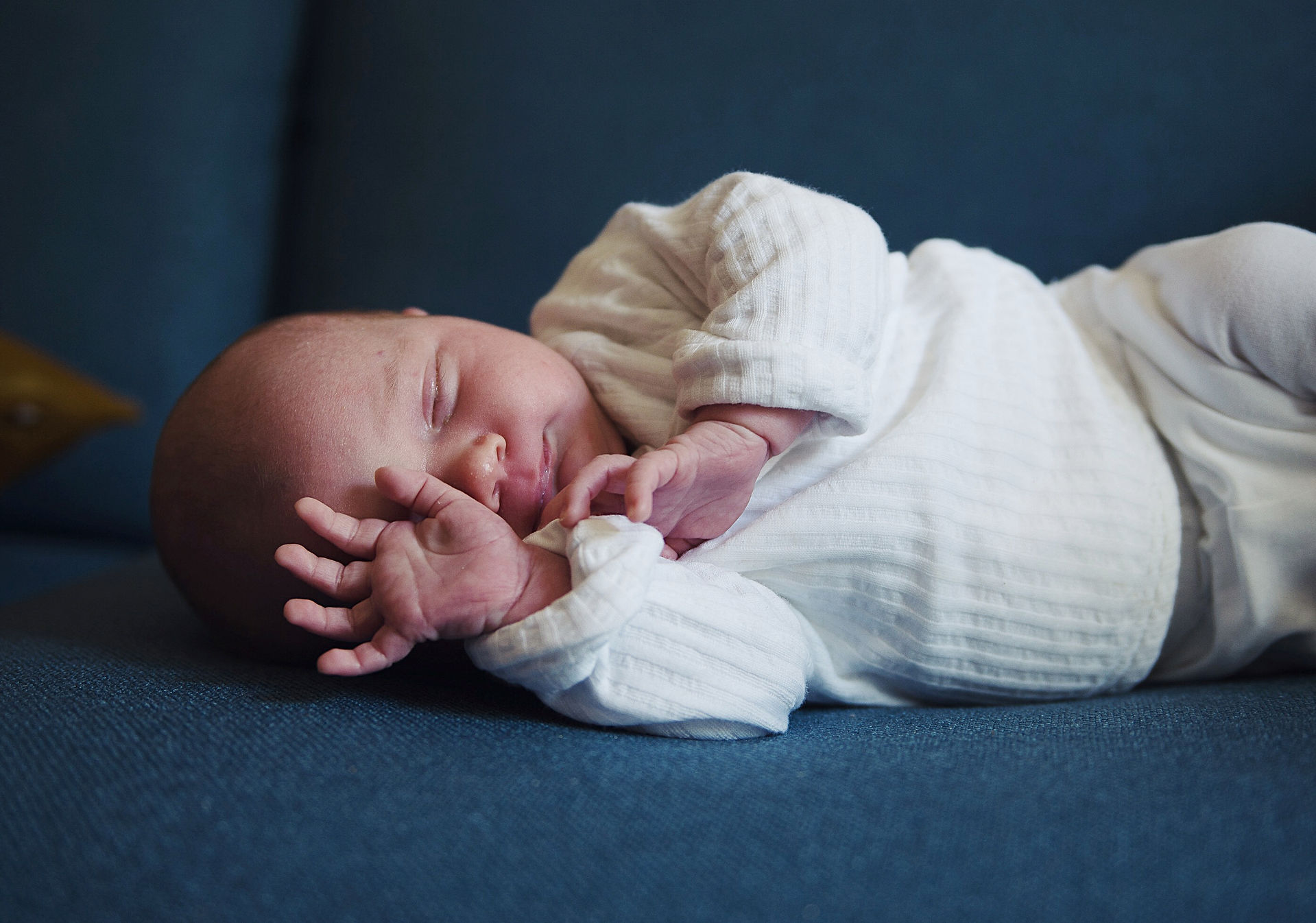 Newborn baby sleeping with hands on his face