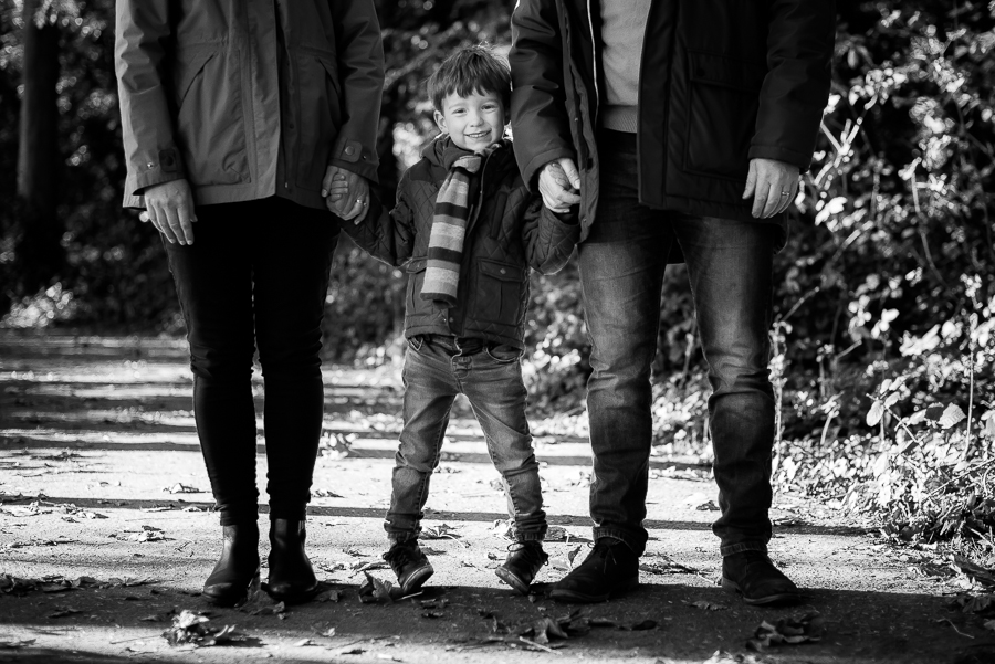 Boy holding hands with his parents out at the garden at Malahide Castle, Dublin