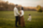 A couple looking at each other and a toddler girl playing in the background