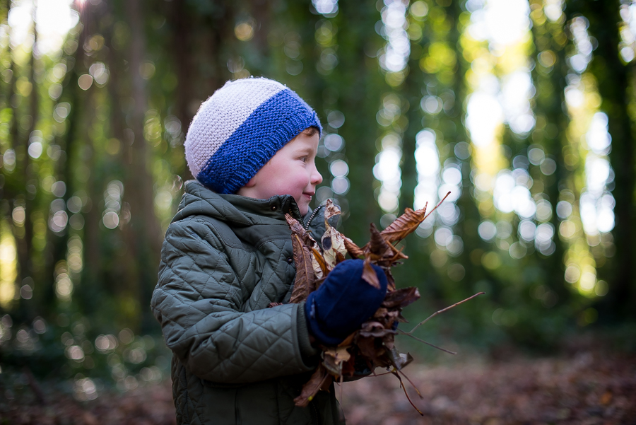 Boy wearing a hat and holding leaves outside  at Malahide Castle, Dublin