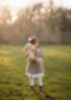 A little girl hugging a teddy bear at a park