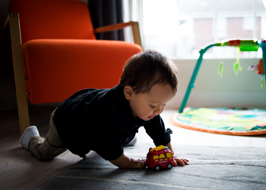 Baby boy playing with toy car - Family session at home in Dublin by Camila Lee