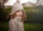 A girl with curly hair waring a winter hat