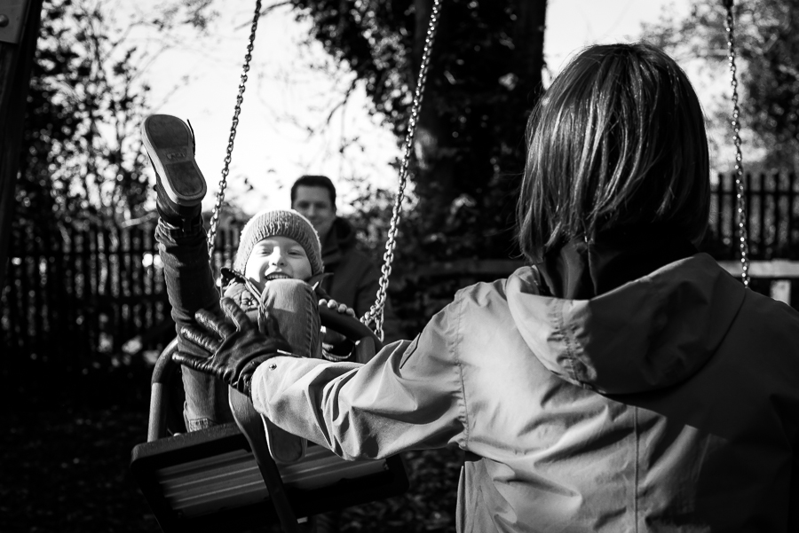 Mother pushing her son on a swing at Malahide Castle Playground in Dublin in Ireland
