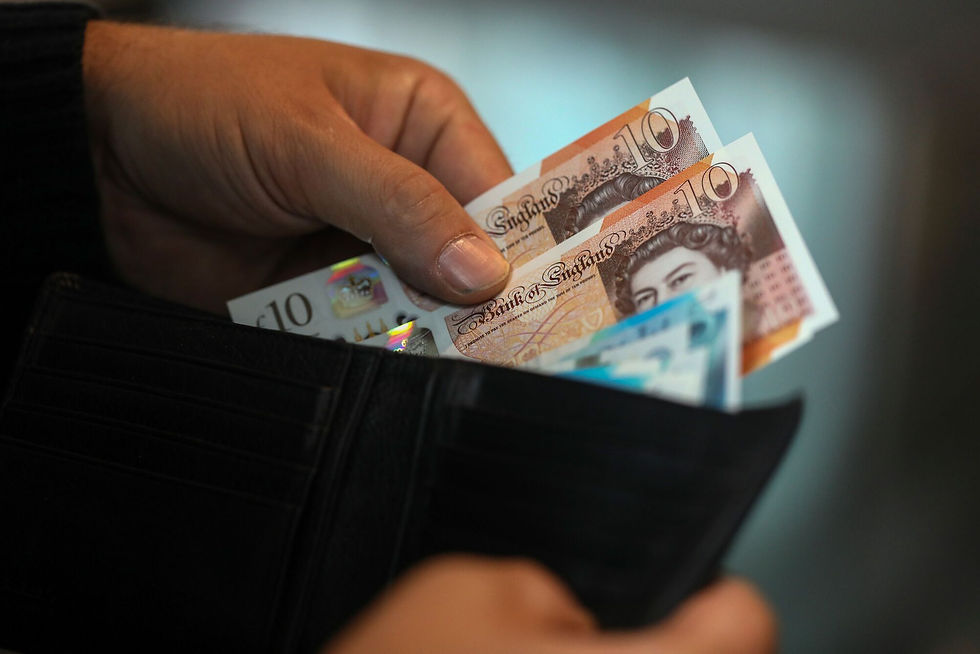 Person holding £10 banknotes from a wallet