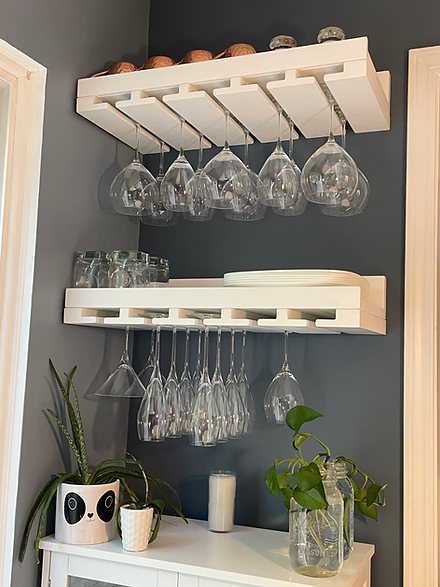 White wooden wine rack with glasses, plants, and other kitchen items displayed.