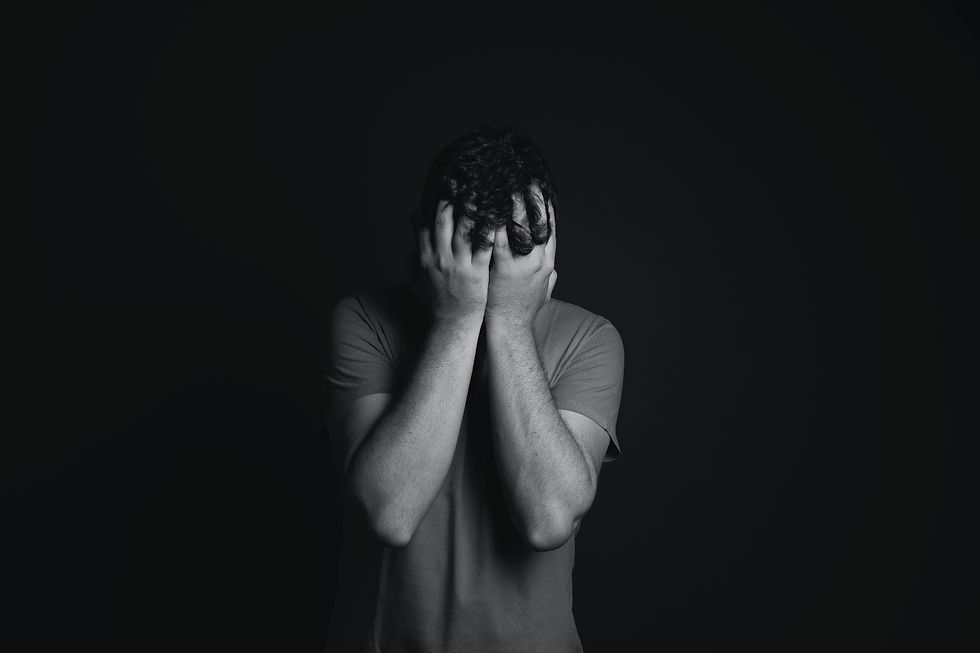 The picture is describing a depressed man, who is holding his head in fear and hiding away from the harsh reality of the real world.