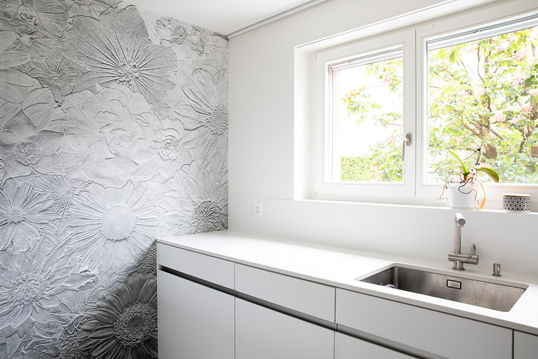 Küche mit silberner, floraler Tapete, die mit dezenten Musterdetails für einen eleganten und modernen Akzent sorgt