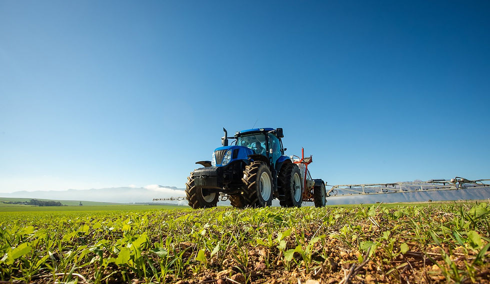 Tractor working a field of crops