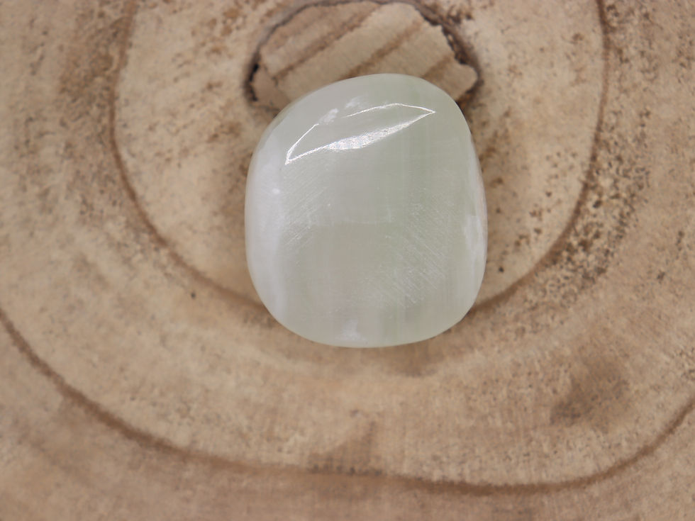 a top view of a green calcite pebble on a natural log base