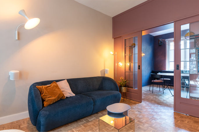 Living room, modern elegance with a stylish blue sofa, Rotterdam, designed by Studio Huis Arrest – photo by Filippo Rossi.
