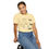 Thumbnail: T-shirt with a line drawing odd a relaxed looking child stimming by listening to music, using a tangle fidget, and moving. The shirt has text that says "Let Kids Stim" | color: banana