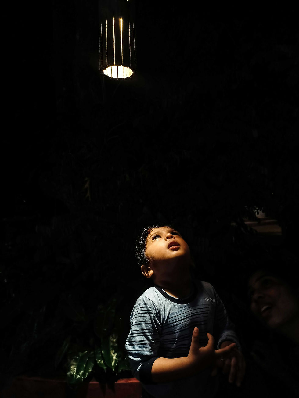 A single glowing lamp on a dark background, symbolising the call to illuminate the world.