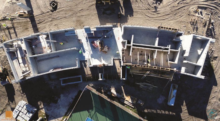 Aerial view of a building's construction site with workers and materials