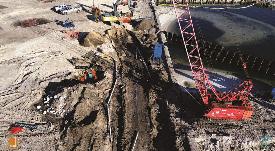 Construction site with a large crane and heavy machinery, working on the project.