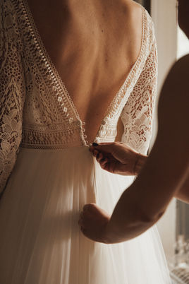 Schönes Dokumentarfoto der Braut, die sich zusammen mit ihrer Brautjungfer auf den großen Tag vorbereitet. Ein emotionaler und authentischer Moment, eingefangen von einem Hochzeitsfotografen aus Zillertal Tirol