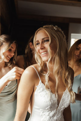 Die schöne, blonde Braut bereitet sich zusammen mit ihren Brautjungfern auf den großen Tag vor. Ein intimer und emotionaler Moment, eingefangen von einem Hochzeitsfotografen aus Zillertal Tirol.