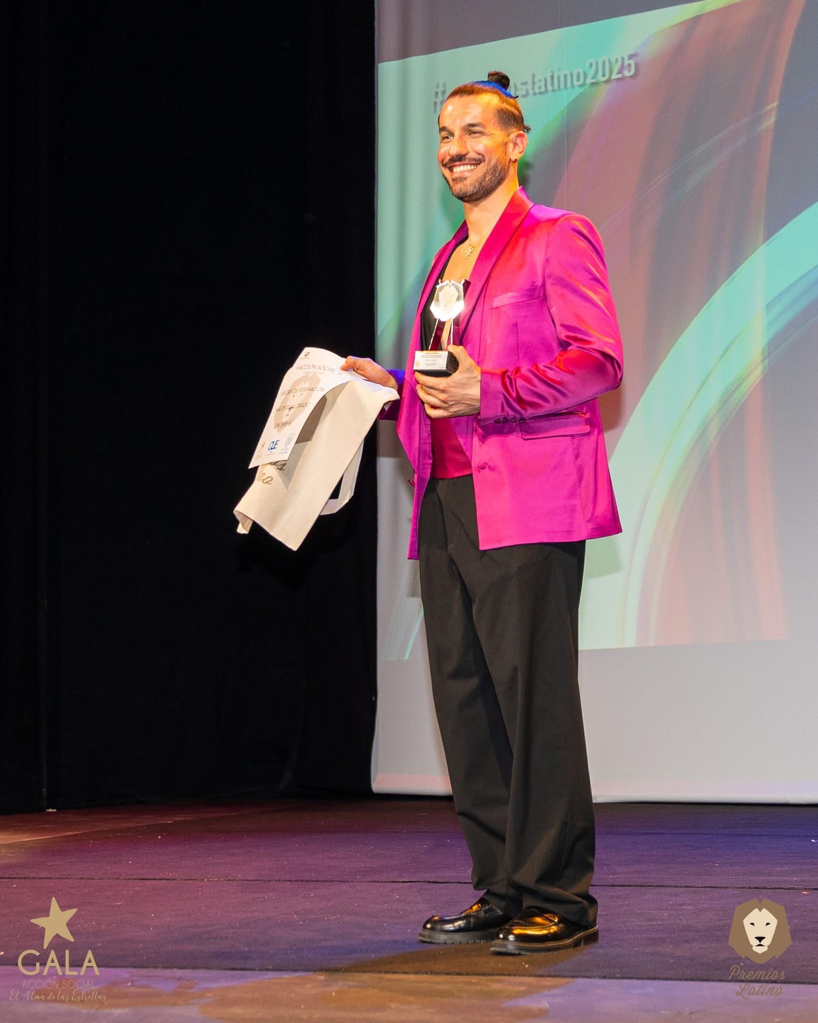 Cristian Toppeta con premio y chaqueta fucsia en los Premios Latino.
