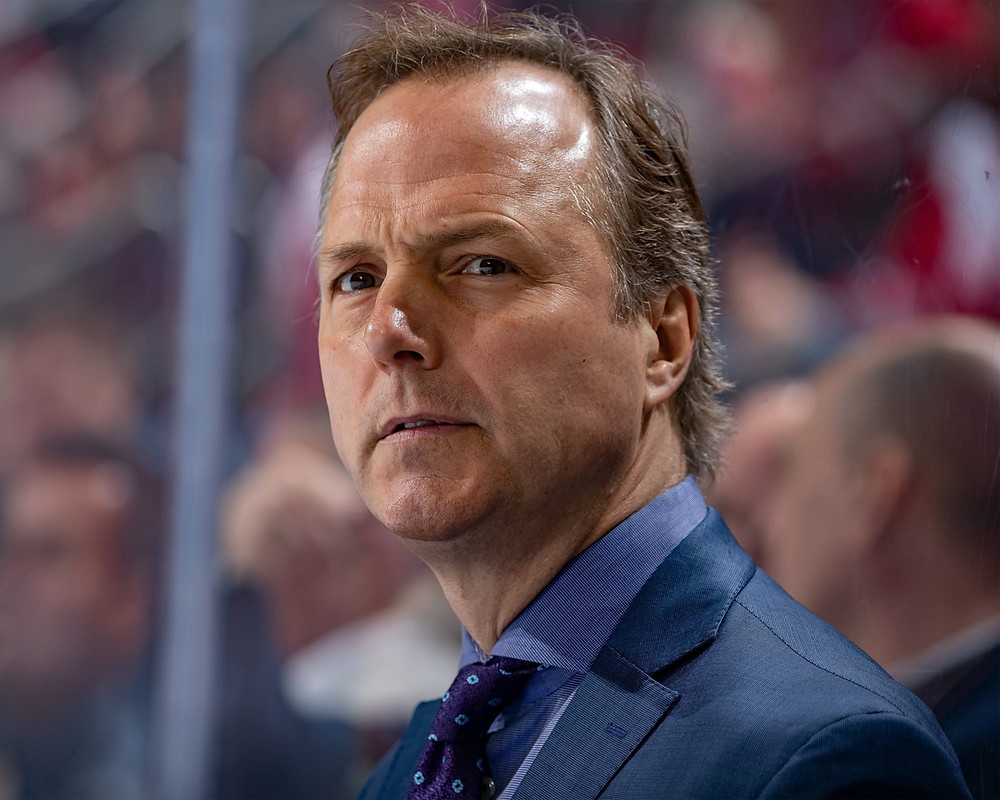 Jon Cooper standing behind the NHL's Tampa Bay Lightning during an NHL game.