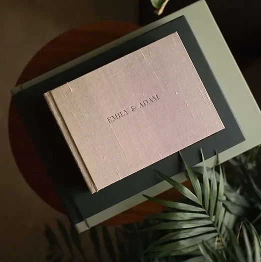 landscape handcrafted album for a couples session. pink textured cover on a table with close up of leaf
